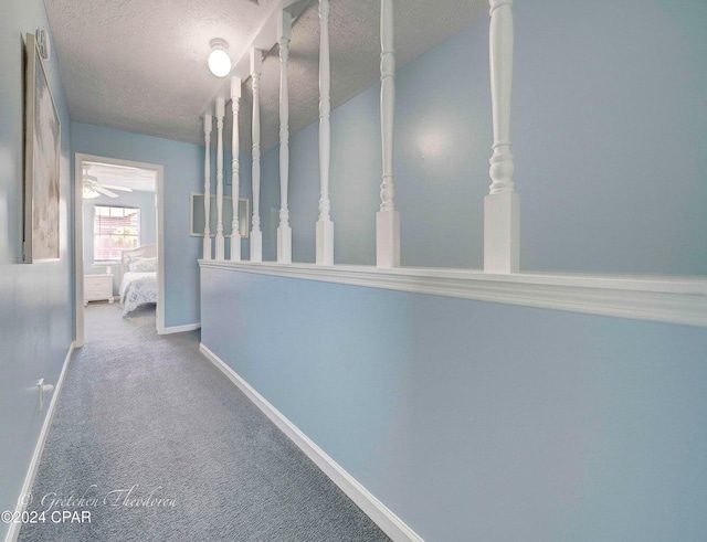 hallway featuring carpet and a textured ceiling