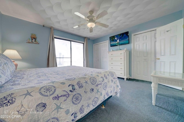 bedroom featuring multiple closets, ceiling fan, and carpet flooring