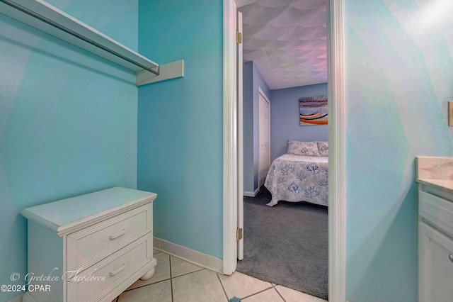 walk in closet with light tile patterned floors