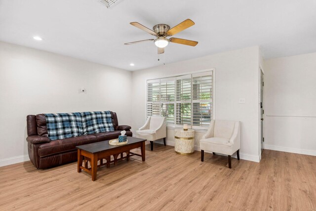 living room featuring ceiling fan and light hardwood / wood-style flooring