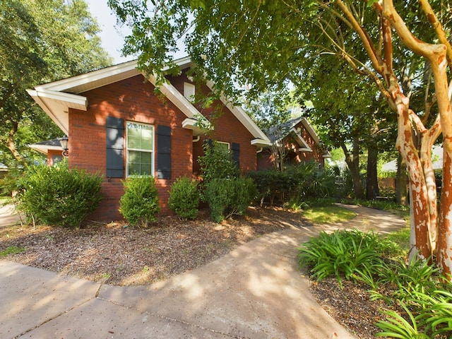 view of front of property featuring brick siding and fence