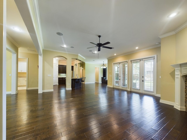 unfurnished living room featuring a ceiling fan, dark wood finished floors, a fireplace, and baseboards