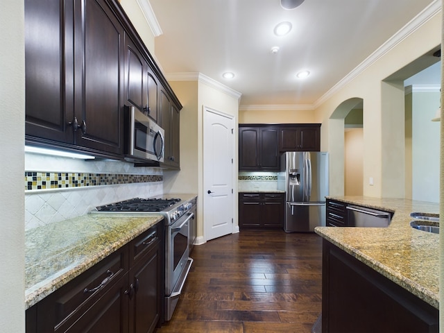 kitchen featuring dark hardwood / wood-style floors, light stone counters, stainless steel appliances, crown molding, and tasteful backsplash