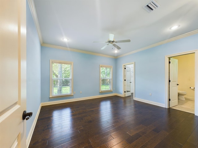 empty room with crown molding, wood-type flooring, visible vents, and baseboards