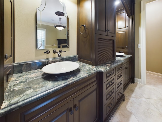 bathroom featuring crown molding, double vanity, and tile patterned flooring