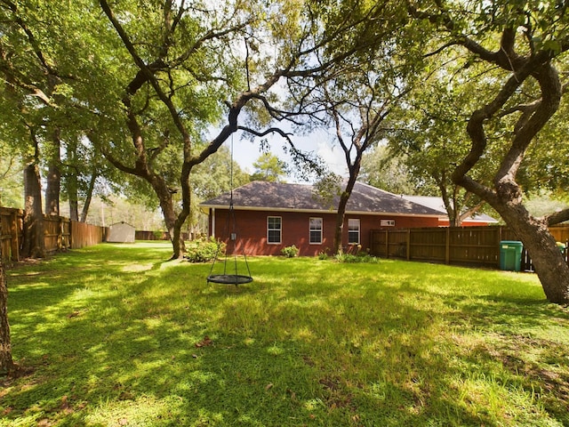 view of yard with a storage shed, an outdoor structure, and a fenced backyard