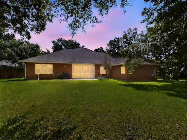 view of front of house with a yard and fence