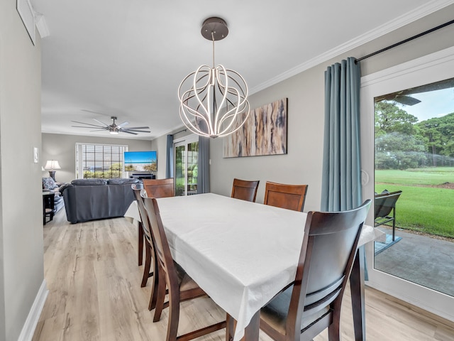 dining space featuring ceiling fan with notable chandelier, ornamental molding, and hardwood / wood-style flooring