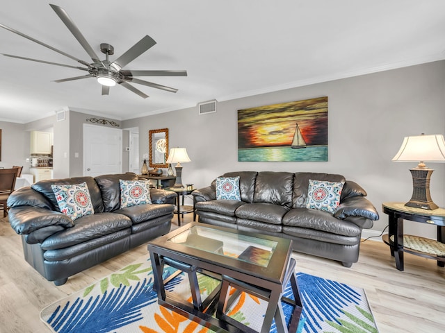 living room with light hardwood / wood-style flooring, ceiling fan, and ornamental molding