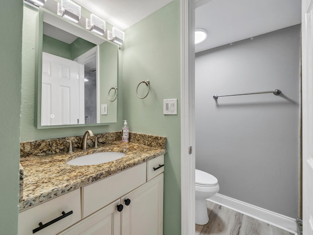 bathroom featuring vanity, toilet, and hardwood / wood-style floors