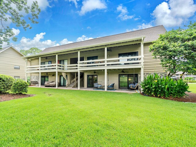 rear view of property featuring a yard, a patio area, and a balcony