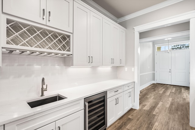 bar featuring white cabinets, beverage cooler, sink, dark hardwood / wood-style flooring, and crown molding