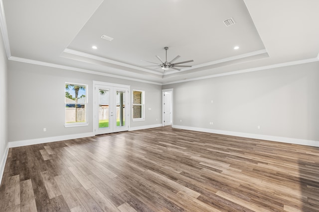 unfurnished room featuring a raised ceiling, french doors, hardwood / wood-style floors, and ceiling fan