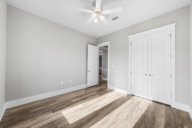 unfurnished bedroom featuring a closet, light hardwood / wood-style floors, and ceiling fan