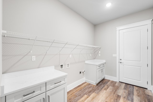 clothes washing area featuring hookup for a washing machine, cabinets, and light hardwood / wood-style floors