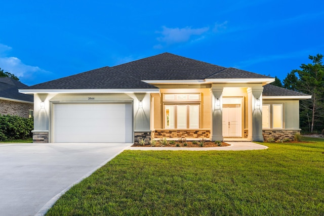 prairie-style home featuring a front lawn and a garage