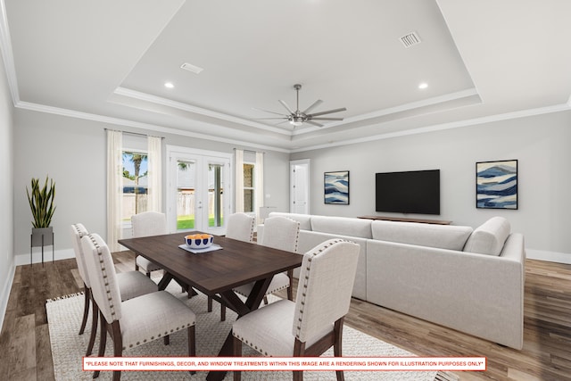 dining space featuring crown molding, a tray ceiling, french doors, and wood-type flooring