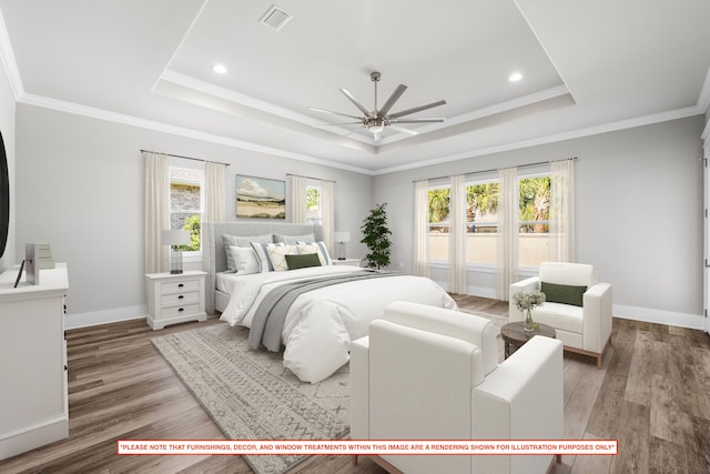 bedroom featuring a raised ceiling, hardwood / wood-style floors, multiple windows, and ceiling fan