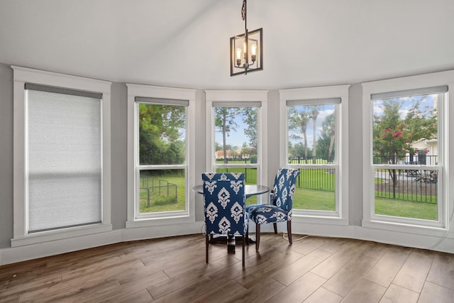 sunroom / solarium featuring a chandelier