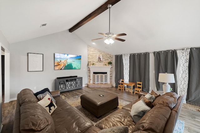 living room featuring dark hardwood / wood-style flooring, a fireplace, beamed ceiling, and ceiling fan