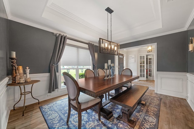 dining area featuring hardwood / wood-style flooring, french doors, and a tray ceiling