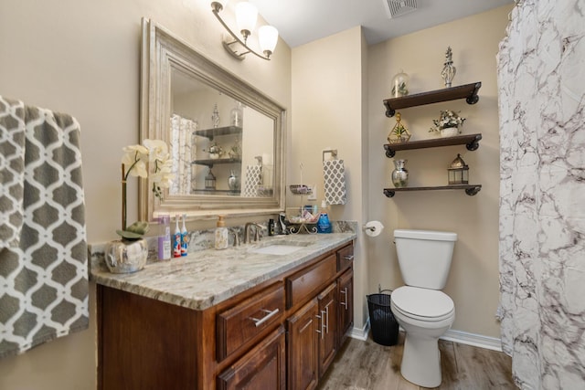 bathroom featuring toilet, hardwood / wood-style flooring, and vanity