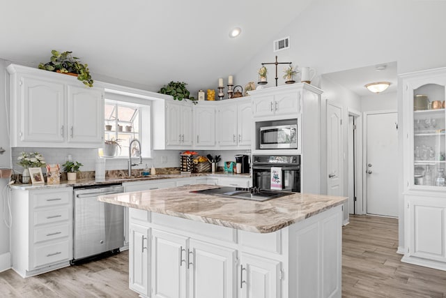 kitchen featuring sink, appliances with stainless steel finishes, light hardwood / wood-style flooring, tasteful backsplash, and white cabinetry