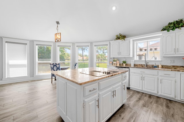 kitchen with white cabinets, backsplash, a wealth of natural light, and a kitchen island