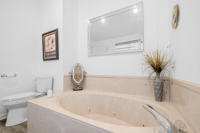 bathroom with toilet, hardwood / wood-style floors, and a bath