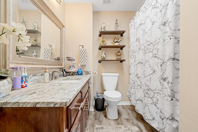 bathroom featuring wood-type flooring, vanity, and toilet