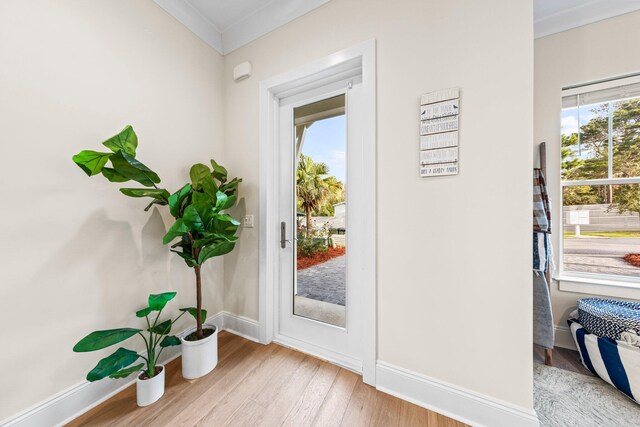 entryway featuring crown molding and light wood-type flooring