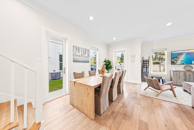 dining space featuring crown molding and light wood-type flooring