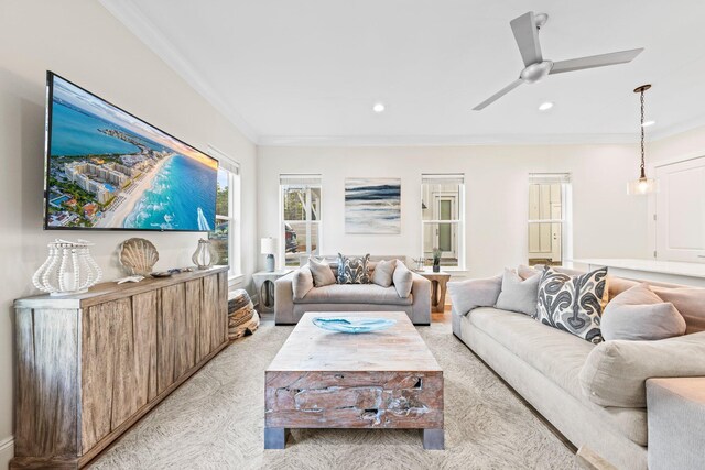 living room featuring ceiling fan, ornamental molding, and light colored carpet