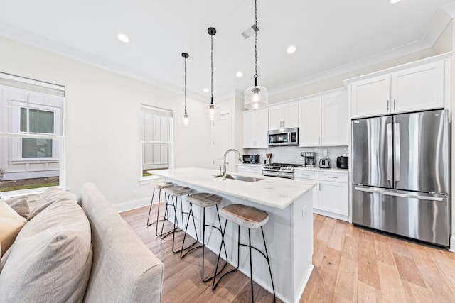 kitchen featuring white cabinetry, light hardwood / wood-style floors, backsplash, and appliances with stainless steel finishes