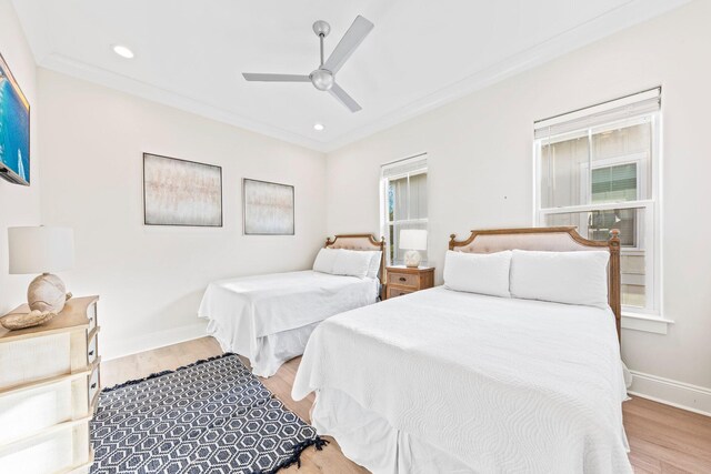 bedroom featuring ornamental molding, light hardwood / wood-style flooring, multiple windows, and ceiling fan