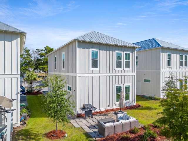 back of property with an outdoor living space, a patio, and a yard