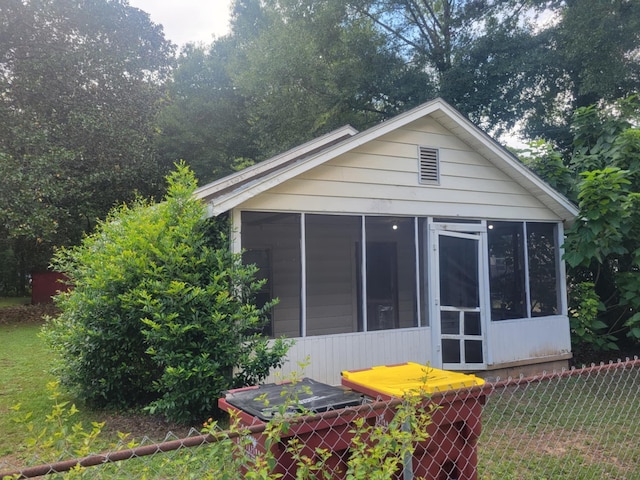 exterior space featuring a sunroom and a yard