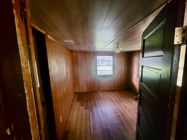 interior space with wooden walls and hardwood / wood-style floors