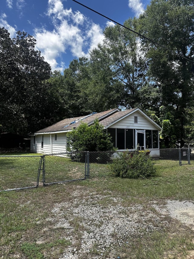 view of front of property featuring a sunroom and a front lawn