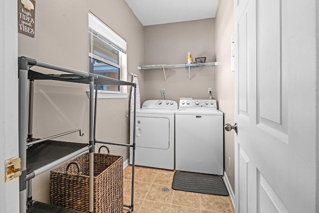 laundry area featuring washer and dryer and light tile patterned floors