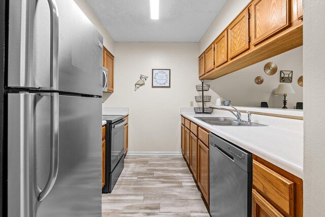 kitchen featuring sink, stainless steel appliances, and light hardwood / wood-style flooring