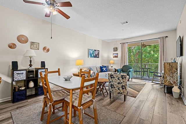 dining room featuring ceiling fan, light hardwood / wood-style flooring, and a textured ceiling