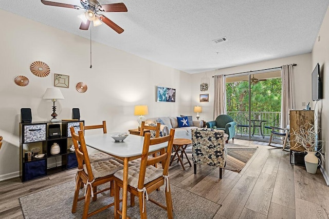 dining area featuring ceiling fan, hardwood / wood-style floors, and a textured ceiling