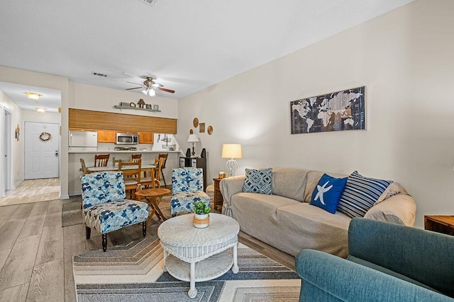 living room featuring ceiling fan and light hardwood / wood-style flooring