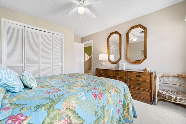 bedroom with carpet floors, a textured ceiling, ceiling fan, and a closet