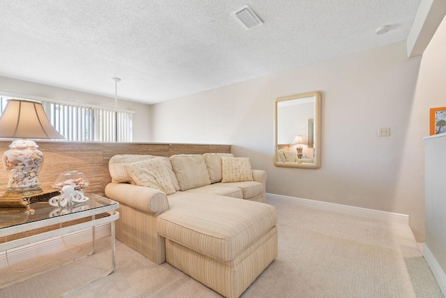 living room featuring light colored carpet and a textured ceiling