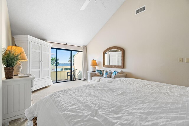 bedroom featuring a water view, access to exterior, ceiling fan, light colored carpet, and high vaulted ceiling