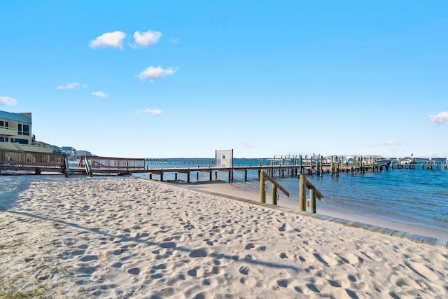 dock area featuring a water view and a beach view