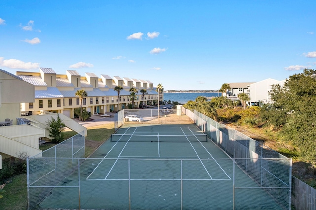 view of tennis court with a water view