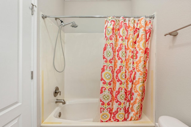 bathroom with toilet and shower / tub combo with curtain